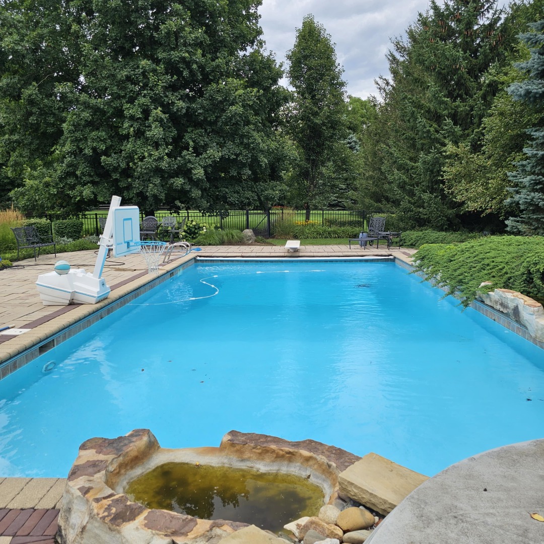 34-w033 White Thorne Road St. Charles, IL 60174 - Photo 93 of 100 a view of a swimming pool with a chair and trees in the background