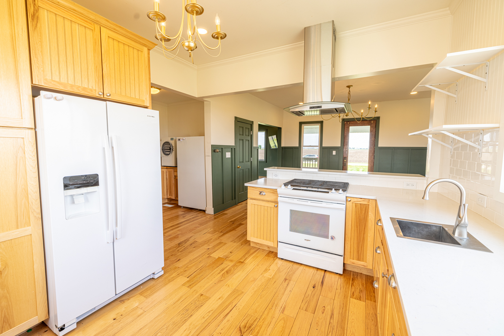 17846 West 3000S Road Buckingham, IL 60917 - Photo 6 of 30 a kitchen with kitchen island granite countertop a stove a refrigerator and a dining table with wooden floors