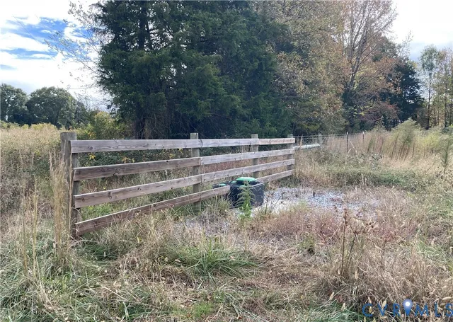 a view of a yard with wooden fence