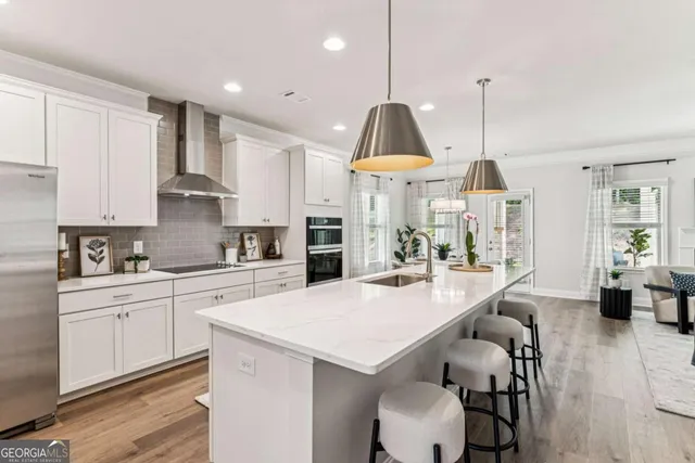 a kitchen with stainless steel appliances a table a sink refrigerator and cabinets
