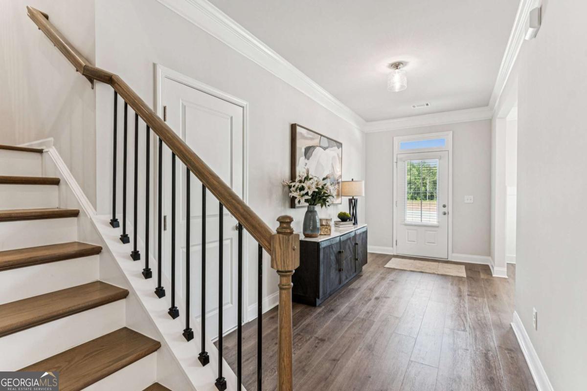 5537 Keswick Drive, Unit 8 Flowery Branch, GA 30542 - Photo 2 of 42 a view of an entryway with wooden floor and stairs