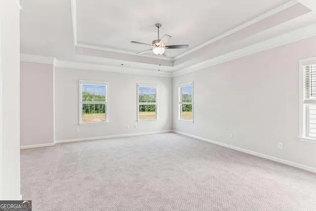an empty room with windows and ceiling fan