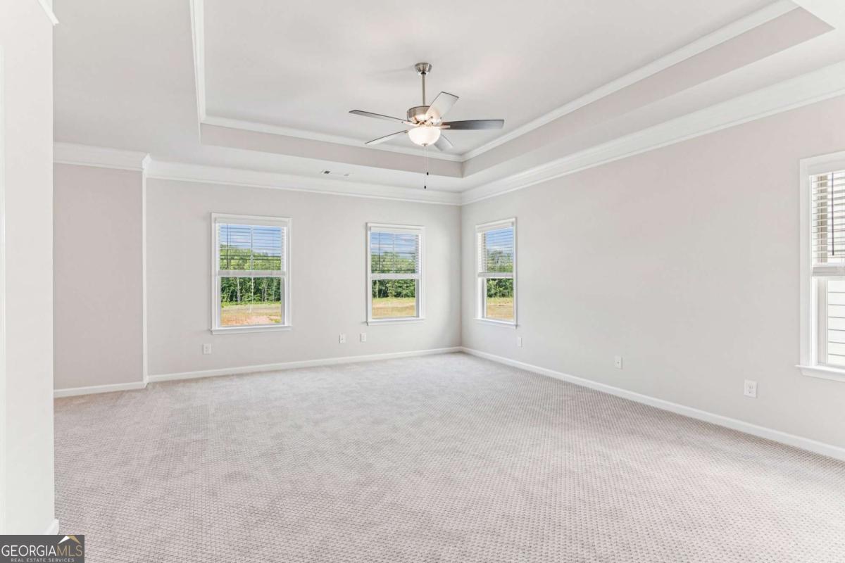 5537 Keswick Drive, Unit 8 Flowery Branch, GA 30542 - Photo 23 of 42 an empty room with windows and ceiling fan