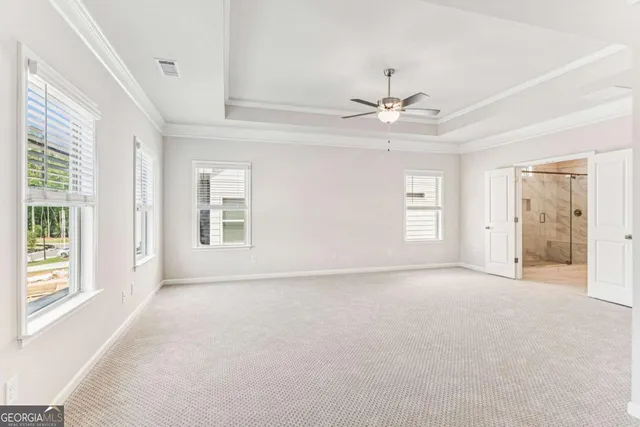an empty room with chandelier fan and windows