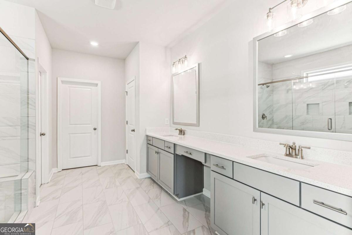 5537 Keswick Drive, Unit 8 Flowery Branch, GA 30542 - Photo 28 of 42 a spacious bathroom with a double vanity sink mirror and double