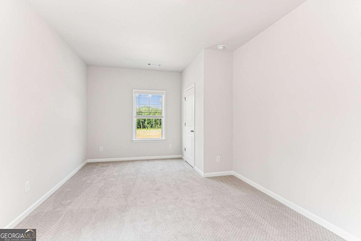 5537 Keswick Drive, Unit 8 Flowery Branch, GA 30542 - Photo 35 of 42 an empty room with windows