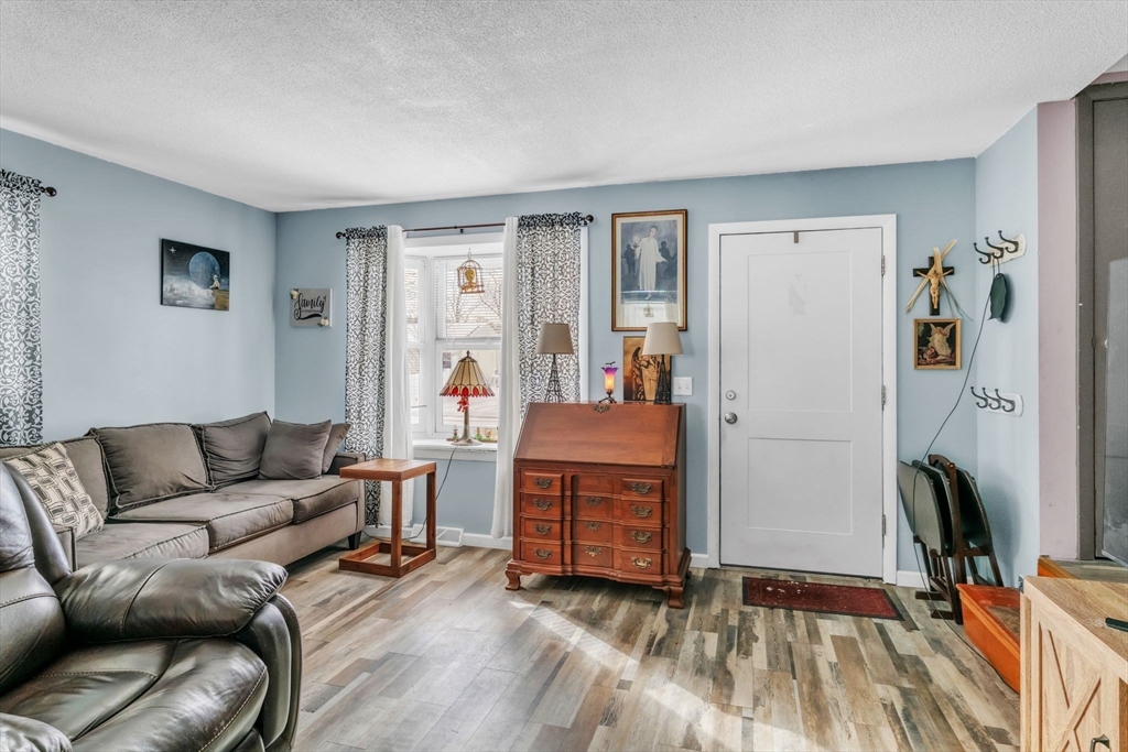 89 Pine Grove Street Springfield, MA 01119 - Photo 3 of 26 a living room with furniture a flat screen tv and a refrigerator