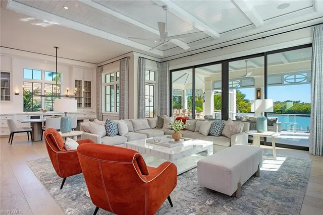 a living room with furniture a large window and chandelier