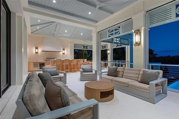 a living room with fireplace furniture and a view of kitchen