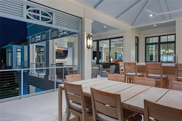 a dining hall with stainless steel appliances kitchen island granite countertop a dining table chairs and a large window
