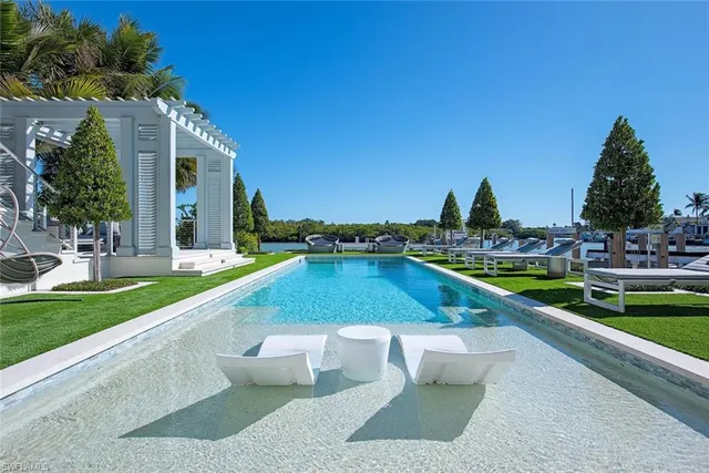 a view of swimming pool with outdoor seating and plants