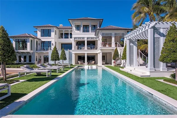 a front view of a house with swimming pool having outdoor seating