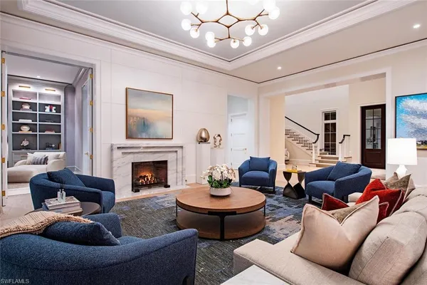 a living room with furniture a fireplace and a chandelier