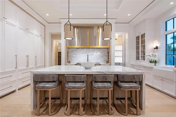 a kitchen with kitchen island stainless steel appliances chairs and wooden floor