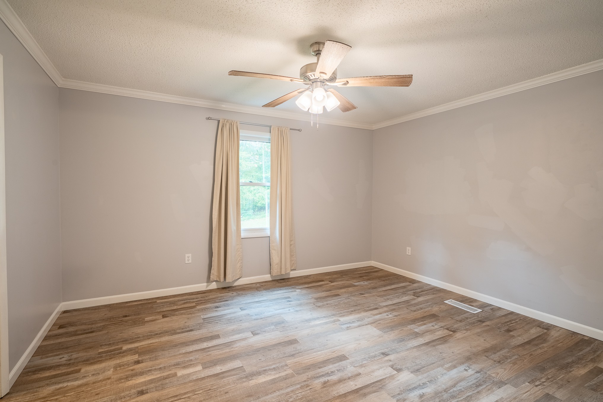 715 Springer Road Hohenwald, TN 38462 - Photo 15 of 30 a view of an empty room with wooden floor and a window