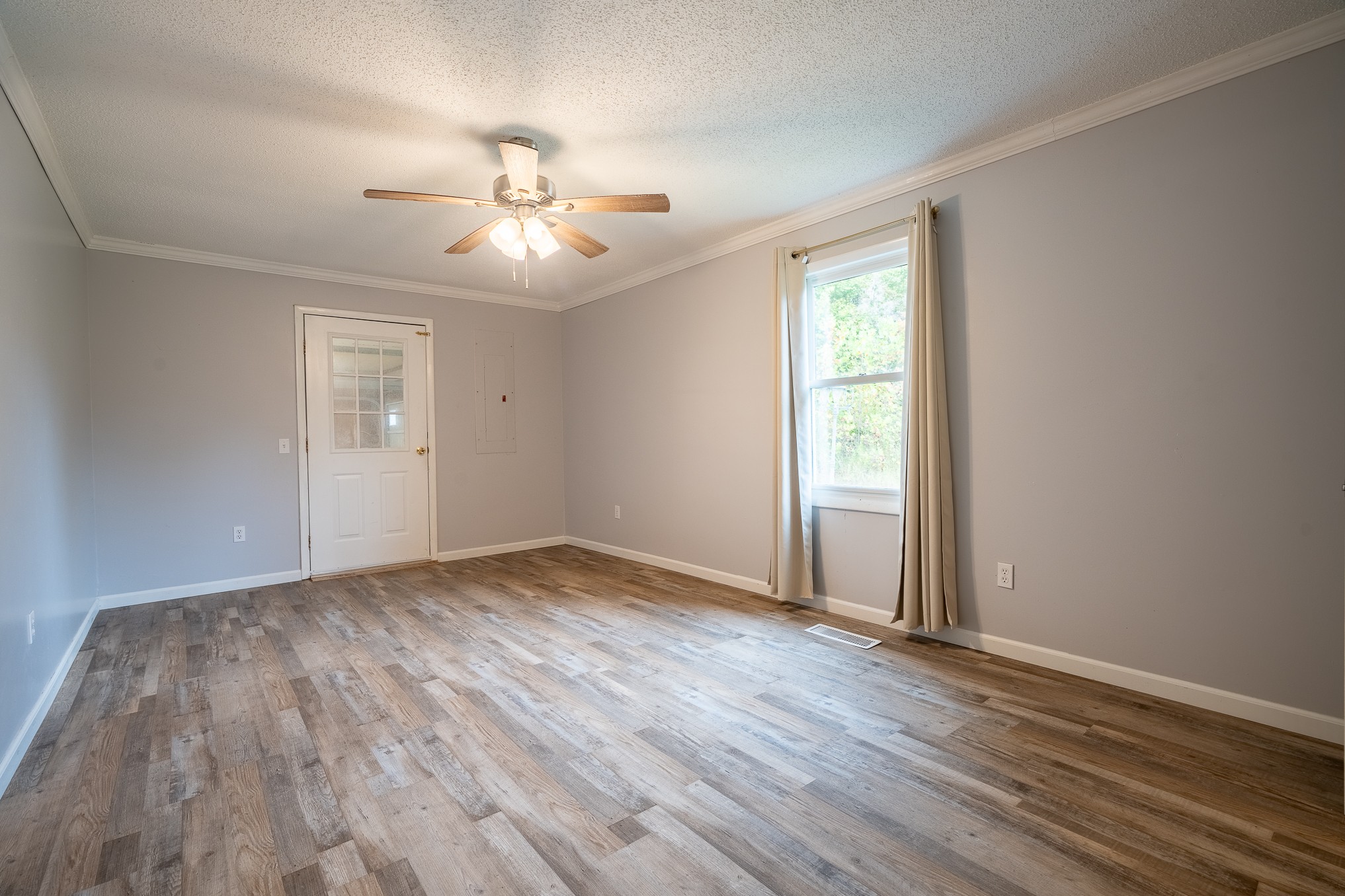 715 Springer Road Hohenwald, TN 38462 - Photo 19 of 30 a view of an empty room with wooden floor and a window