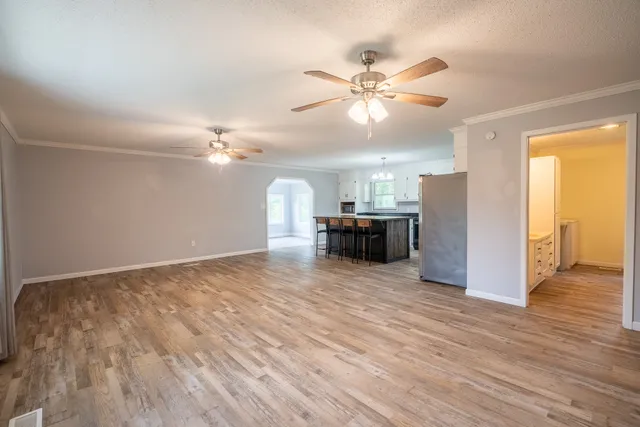 a view of a livingroom with a ceiling fan hardwood floor and a ceiling fan
