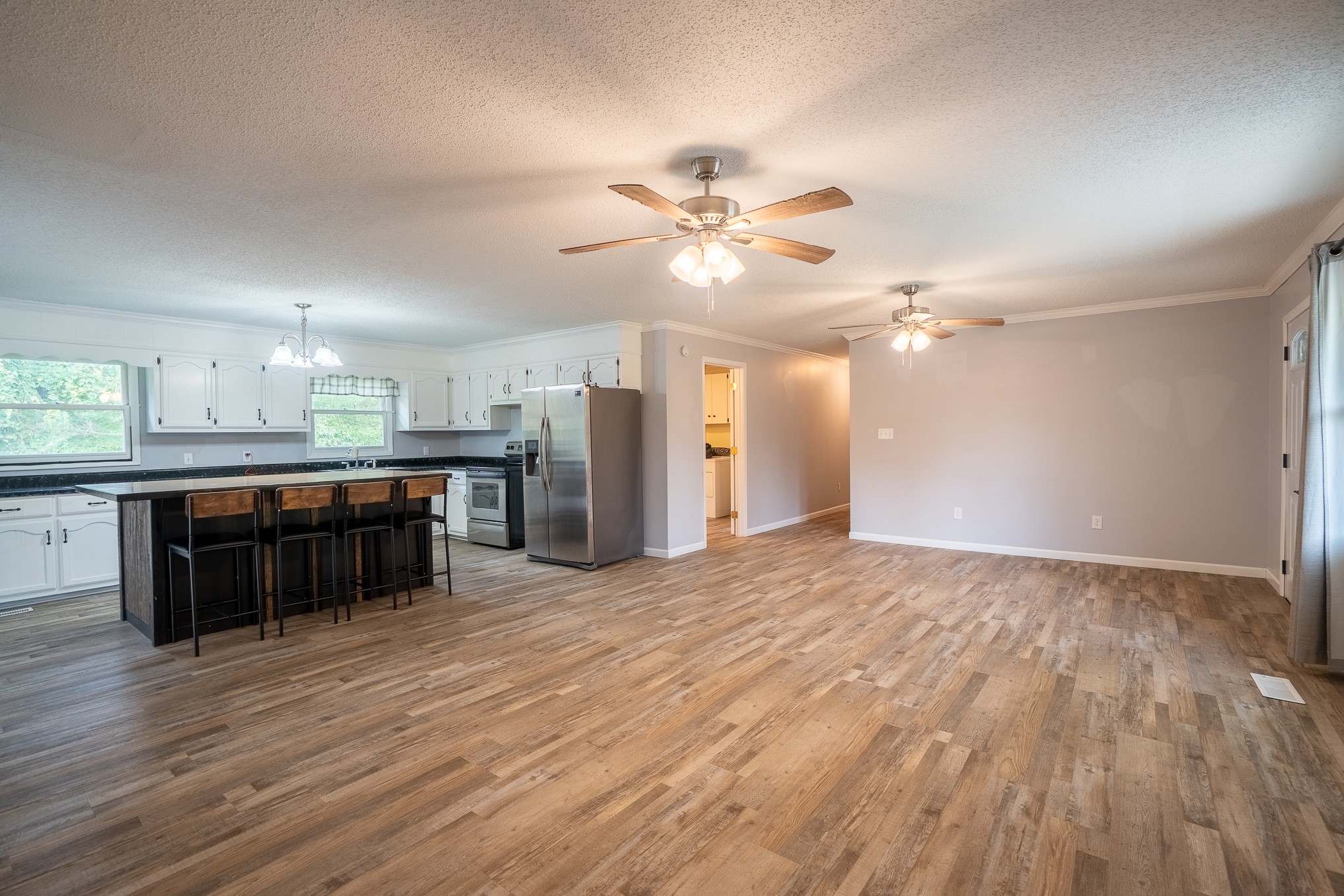 715 Springer Road Hohenwald, TN 38462 - Photo 6 of 30 a large kitchen with stainless steel appliances a large counter top a chandelier and a view of kitchen