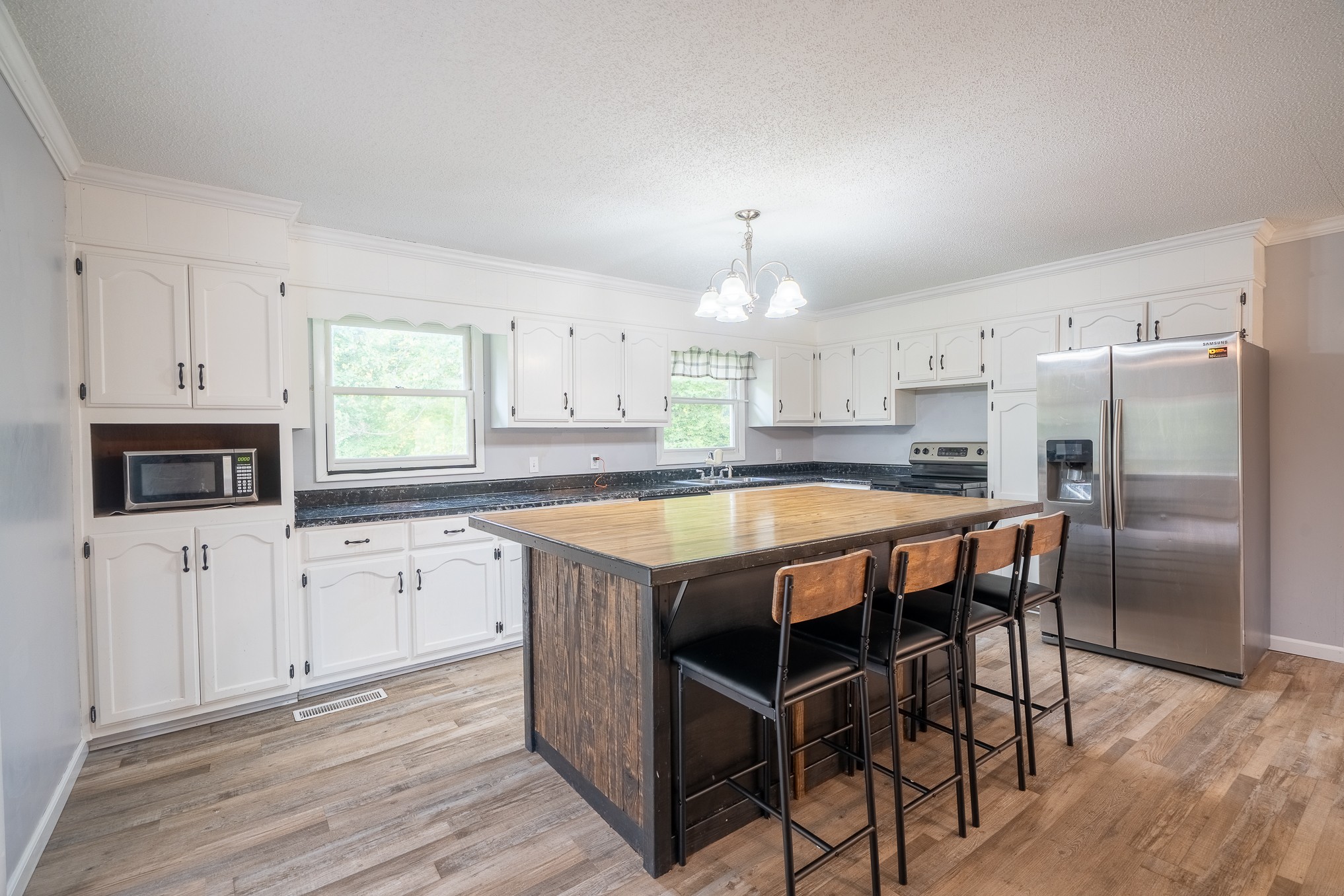 715 Springer Road Hohenwald, TN 38462 - Photo 7 of 30 a kitchen with stainless steel appliances granite countertop a stove a sink dishwasher a refrigerator with white cabinets and wooden floor
