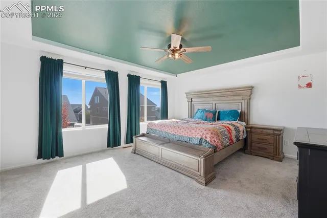 a spacious bedroom with a large bed and a chandelier