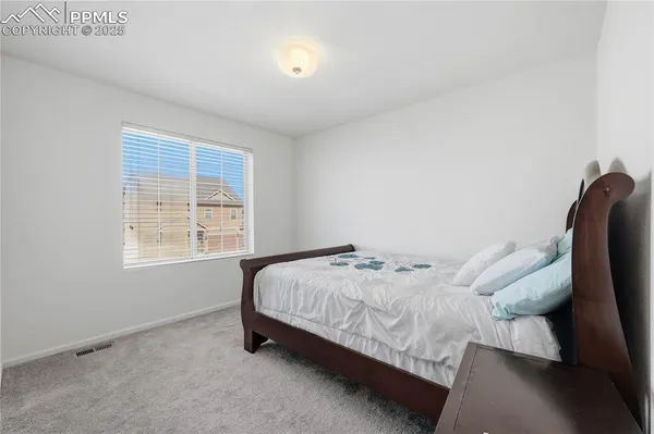 a bed sitting in a bedroom next to a window