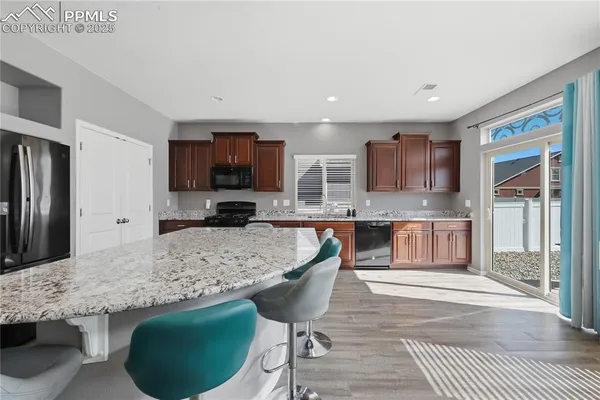 a kitchen with stainless steel appliances granite countertop a stove a sink a microwave a refrigerator and cabinets