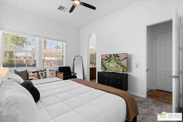 a bedroom with a bed and painting on the wall