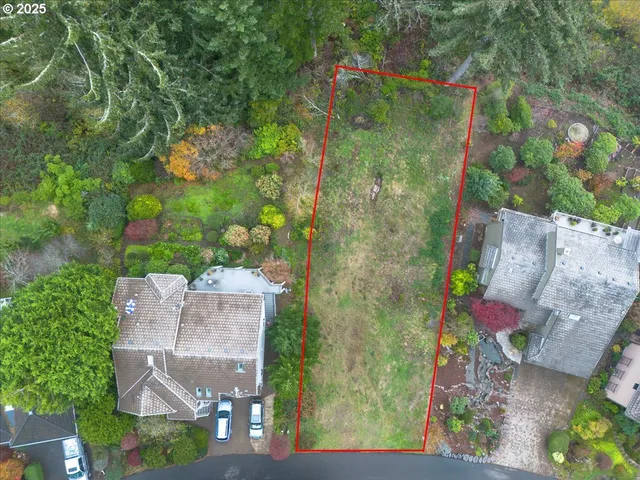 an aerial view of residential house with outdoor space and trees all around