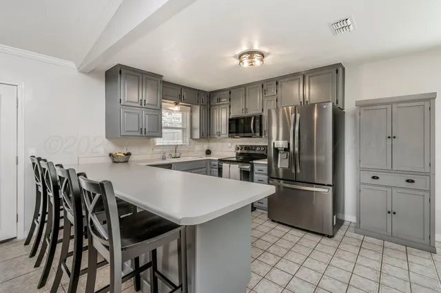 a kitchen with stainless steel appliances a refrigerator stove microwave and cabinets