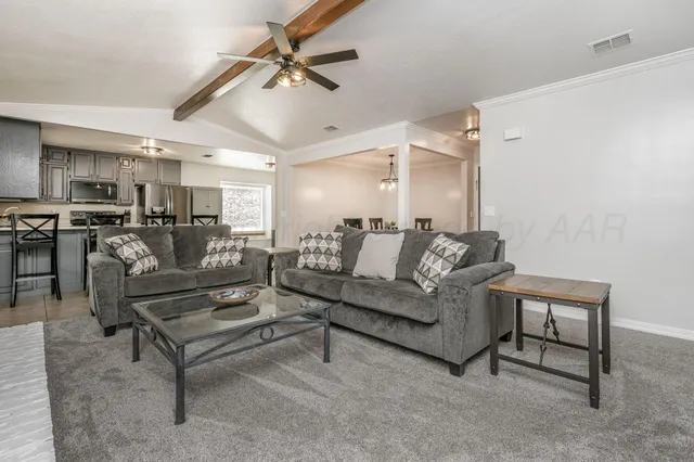 a living room with furniture and kitchen view