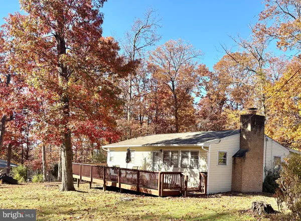 a view of a house with a big yard and large tree