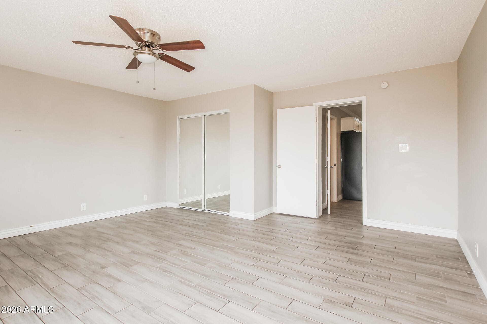 6402 South 44th Street Phoenix, AZ 85042 - Photo 13 of 20 an empty room with wooden floor and a ceiling fan