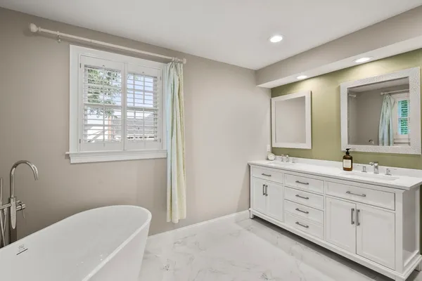 a bathroom with a granite countertop sink mirror and bathtub
