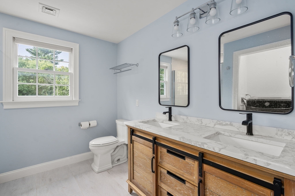 21 Cedar Springs Lane Needham, MA 02492 - Photo 23 of 31 a bathroom with a double vanity sink toilet mirror and window