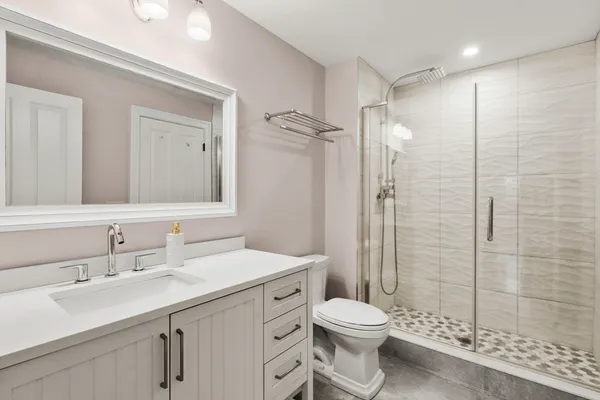 a bathroom with a sink a toilet and shower