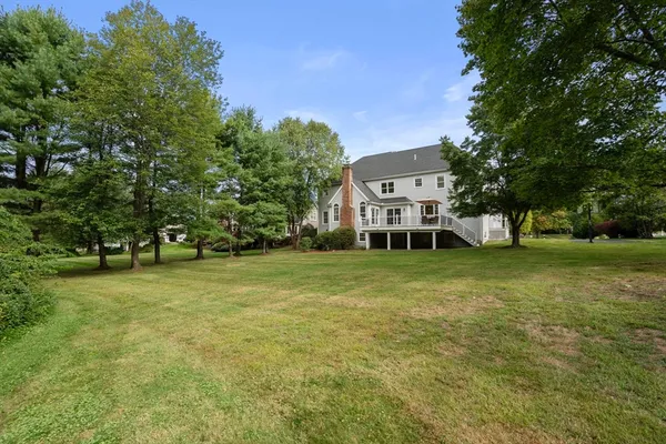 a view of a big house with a big yard and large trees