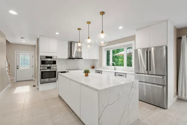 a kitchen with white cabinets and stainless steel appliances
