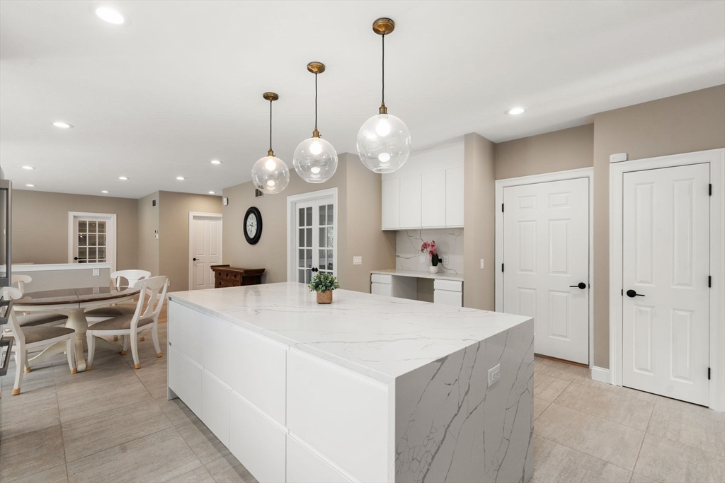 21 Cedar Springs Lane Needham, MA 02492 - Photo 6 of 31 a large kitchen with kitchen island a stove a sink a center island a dining table and chairs