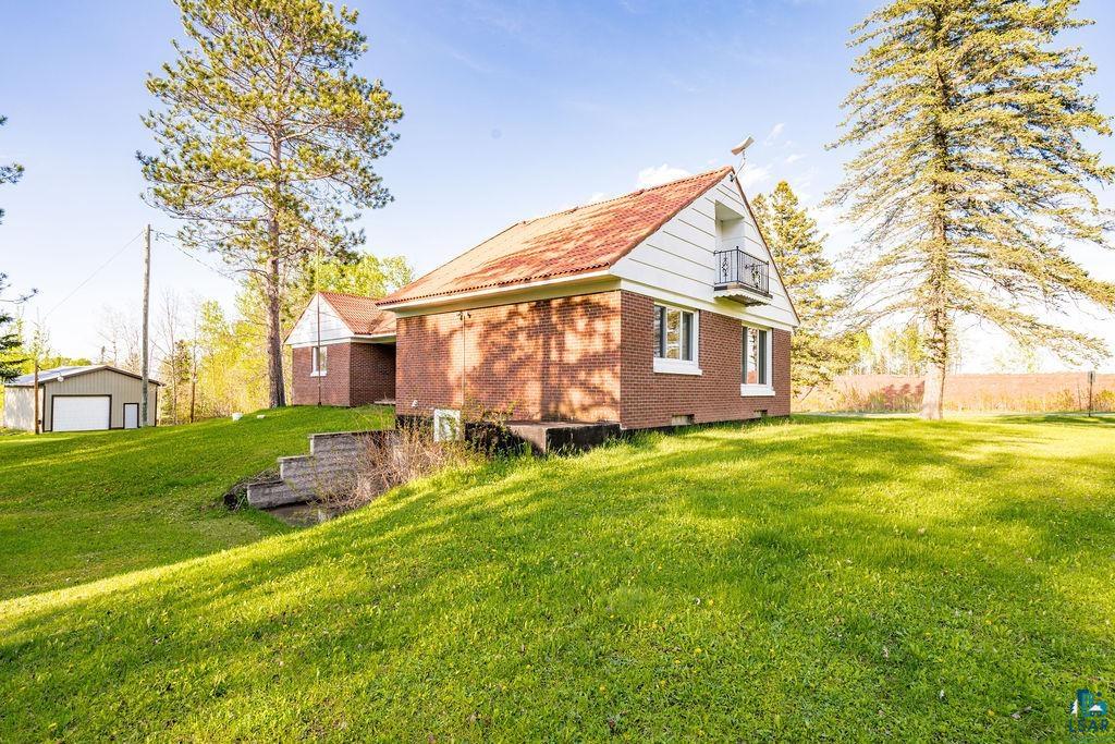 4543 County Road East South Range, WI 54874 - Photo 28 of 43 Brick residence with a prominent gabled roofline and an upper-level balcony featuring decorative railing