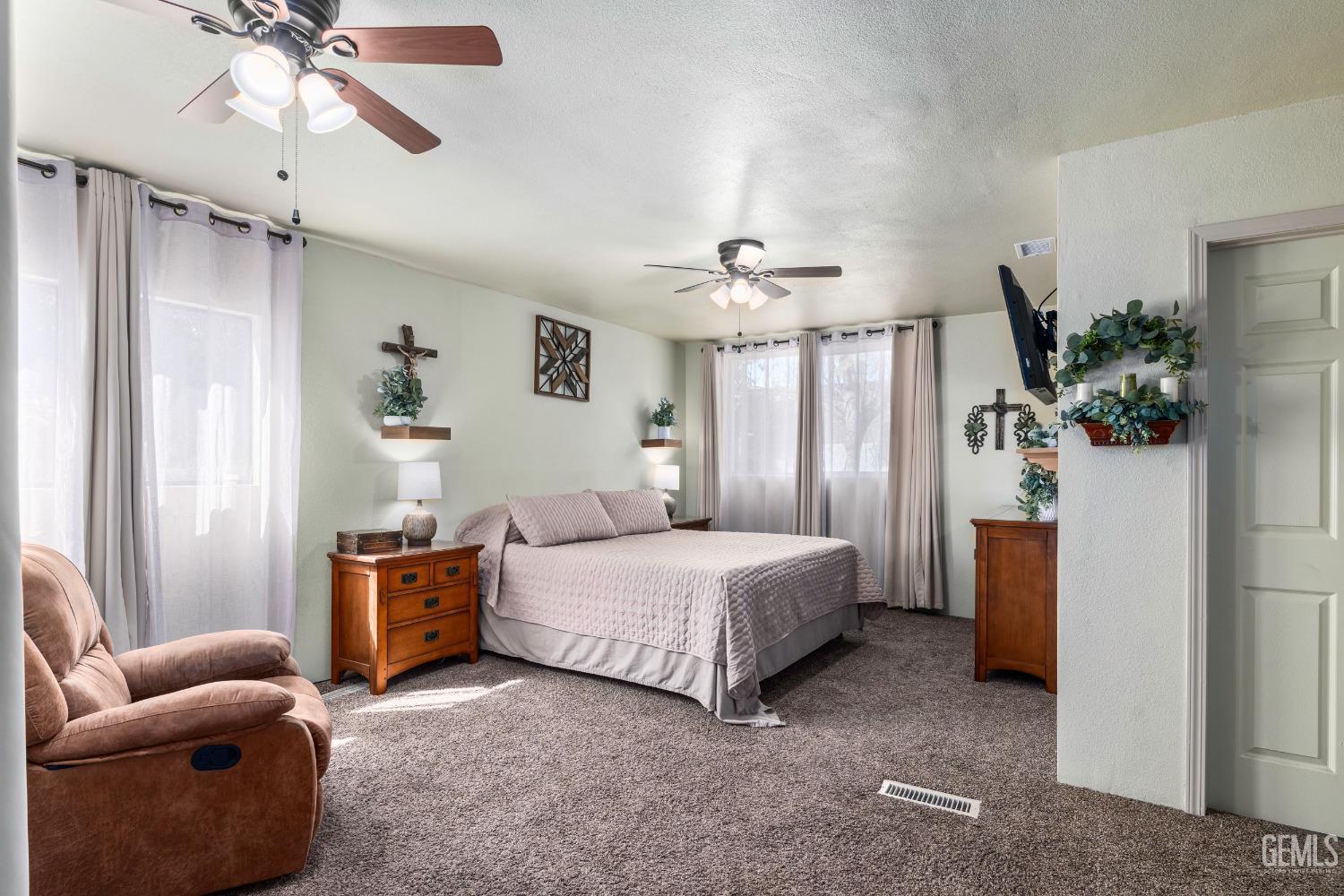 Undisclosed Address Delano, CA 93215 - Photo 19 of 72 a spacious bedroom with a bed and a chandelier