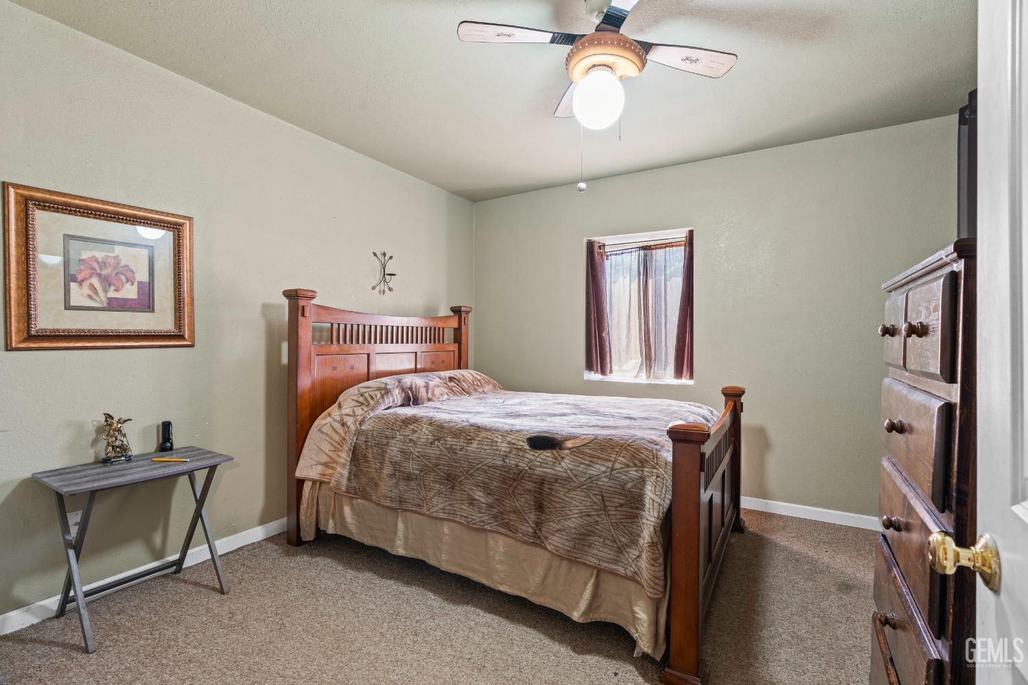 Undisclosed Address Delano, CA 93215 - Photo 30 of 72 a bedroom with a bed and a chandelier