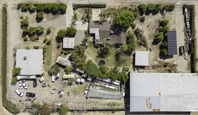 an aerial view of a house with a yard and large trees