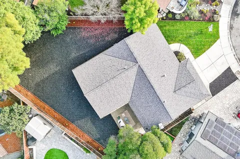 an aerial view of a house with a yard and a large tree