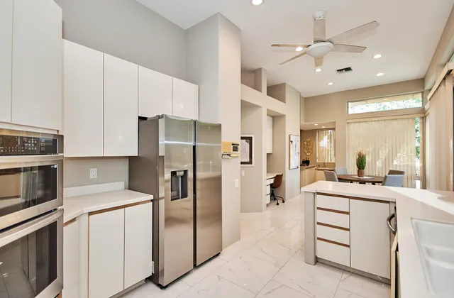 a kitchen with a refrigerator sink and cabinets