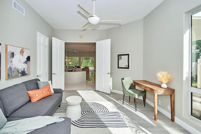 a living room with furniture a chandelier and a painting on the wall