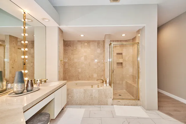 a bathroom with a tub sink and mirror