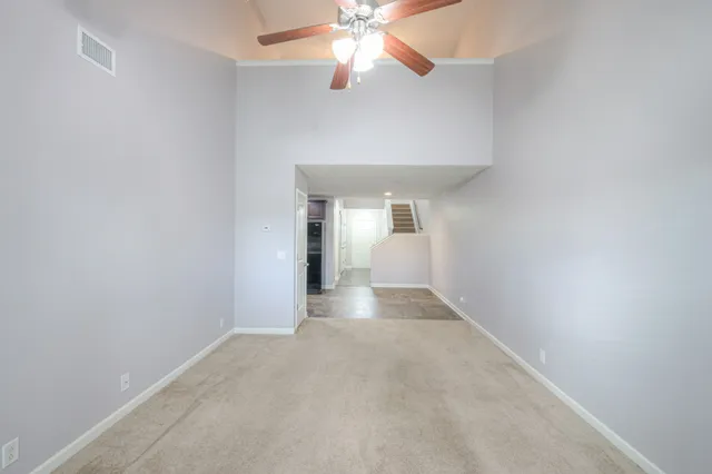 an empty room with a chandelier fan and closet