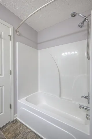 an empty room with windows and chandelier fan