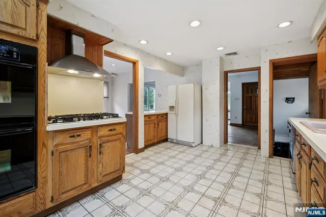 a kitchen with stainless steel appliances granite countertop a refrigerator and a stove top oven