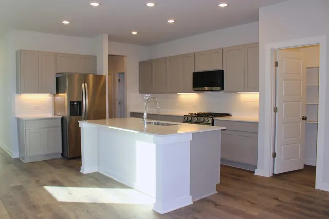 a kitchen with stainless steel appliances granite countertop a refrigerator and a stove top oven